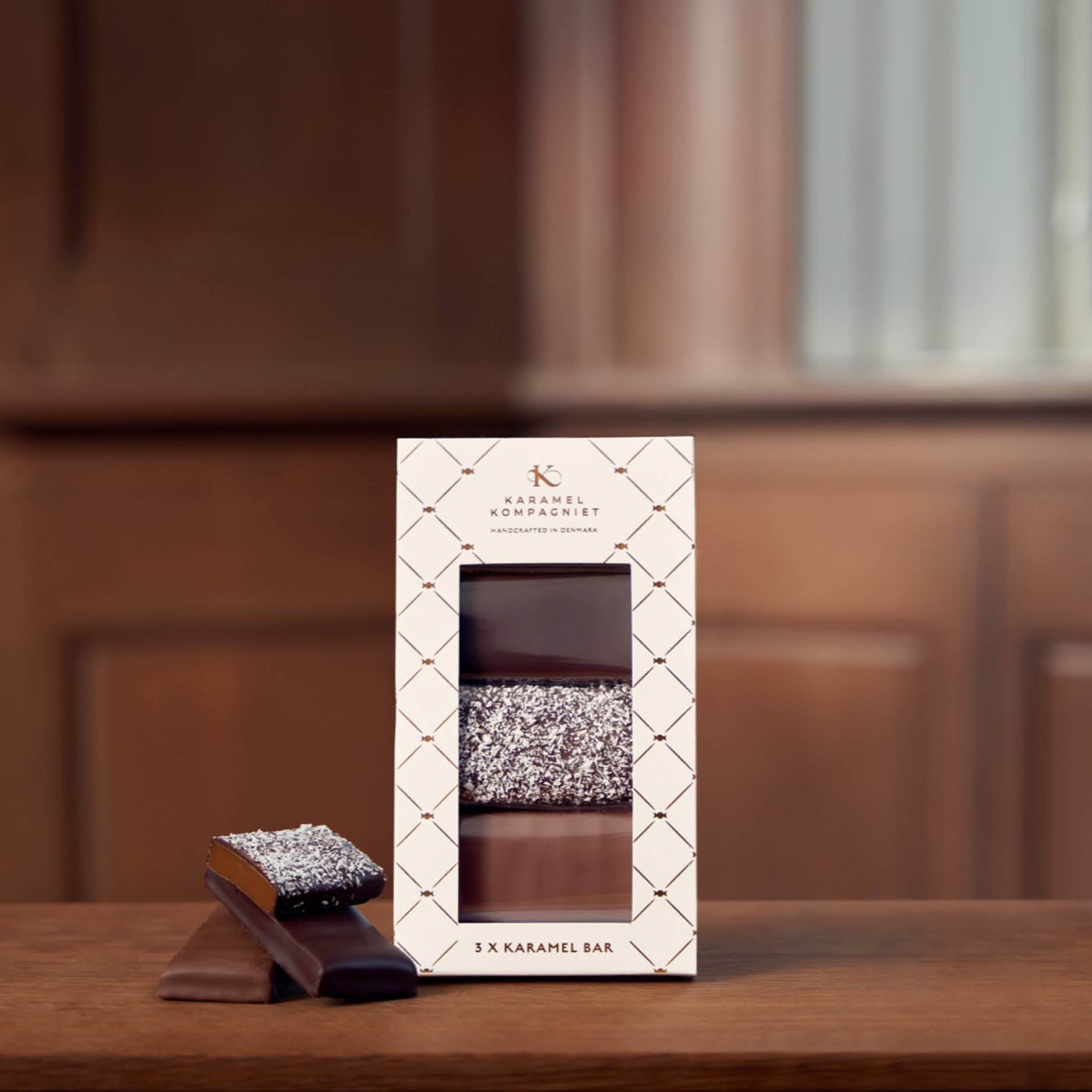 Chokoladeovertrukken Karamel Bar Gaveæske 3 stk. på bord med karamel barer ved siden af