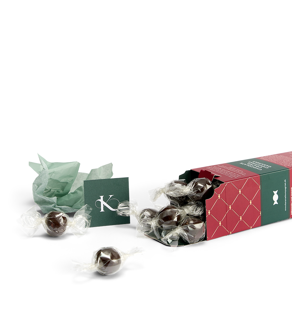 Chokoladeovertrukne Julekaramel Kugler i en æske fra Karamel Kompagniet liggende