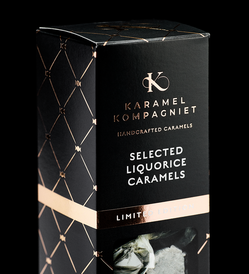 Nærbillede af Selected Liquorice Caramels Limited Edition-æske fra Karamel Kompagniet med guldtryk og rosegold detaljer på sort baggrund